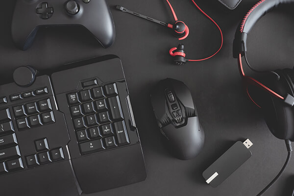 Black gaming keyboard, controller, and headphones